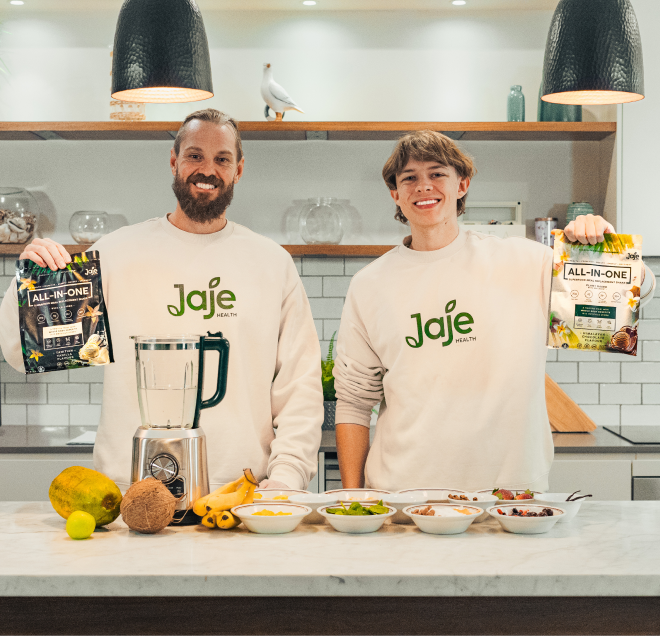 Two men with Jaje All-In-One shakes, blender, and fruit for healthy meal replacement.